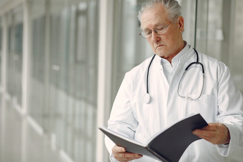 Arzt analysiert Unterlagen im Krankenhausflur